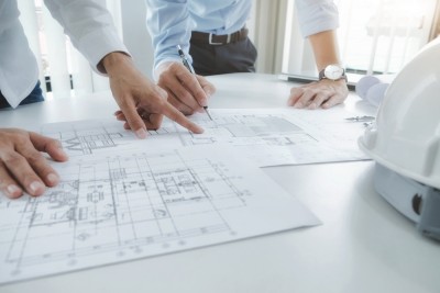 stock image of engineers looking at plans on a table