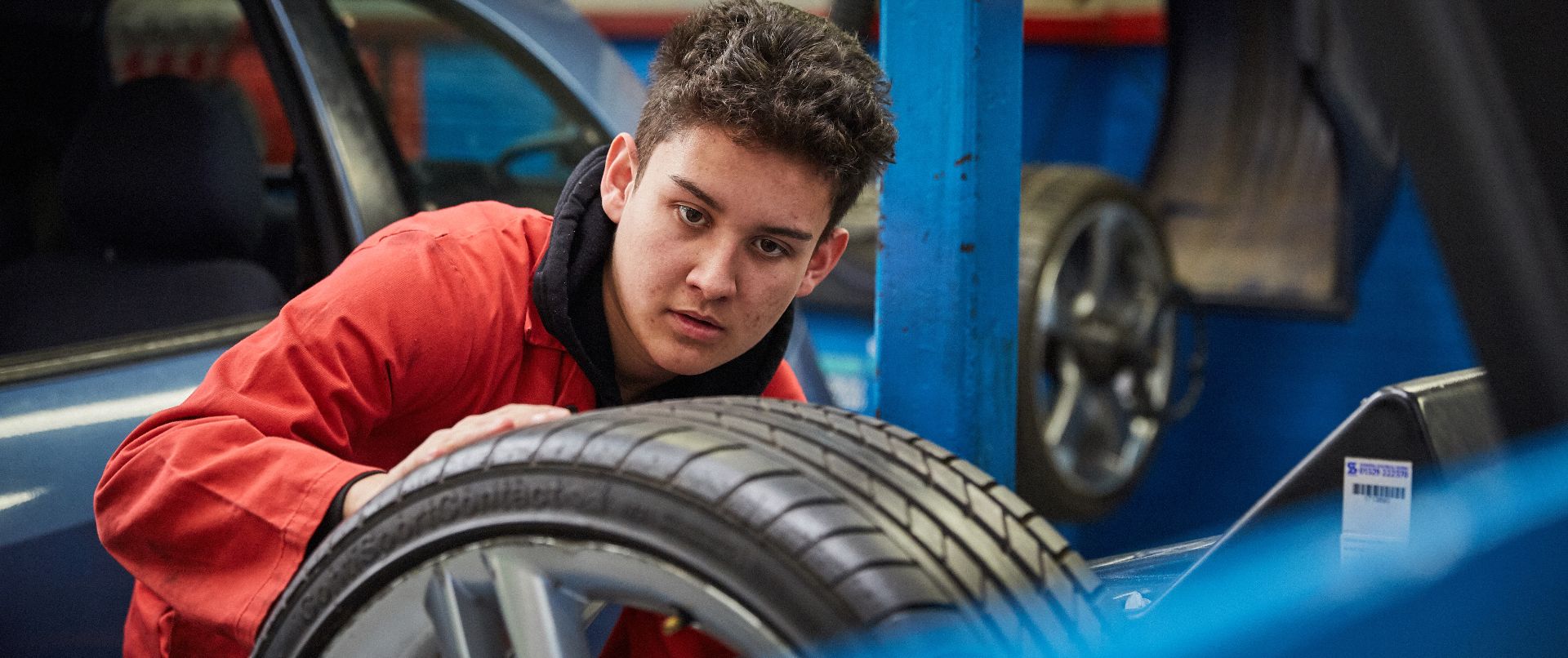 Northbrook motorsport student looking at tyre in the garage facilities