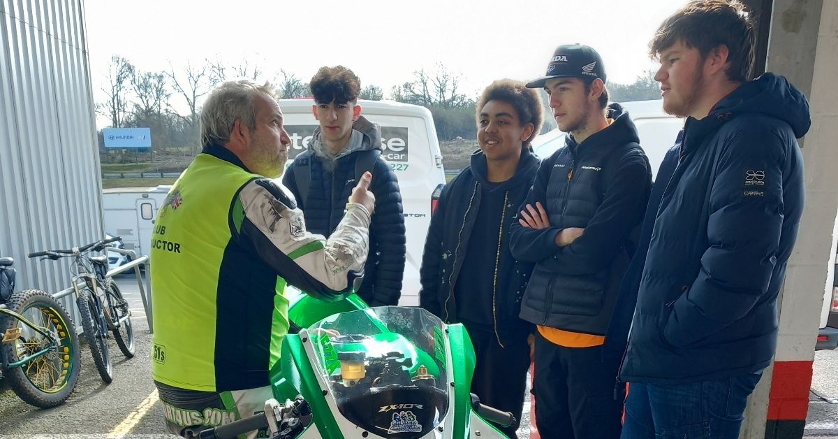 Students stood by a racing bike 