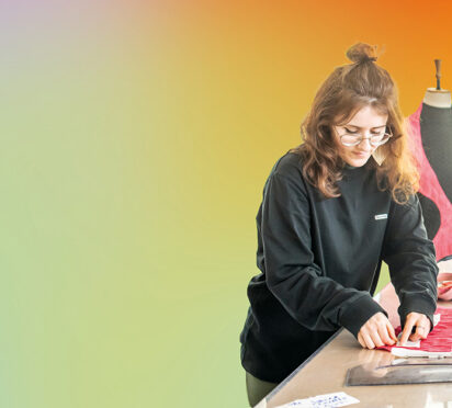Image cut out on a multi-coloured background of a woman in an art and design studio.