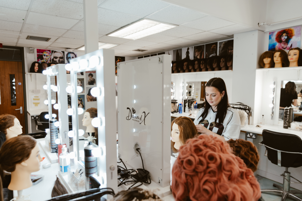A student working with mannequins to practice hair styling within a studio setting