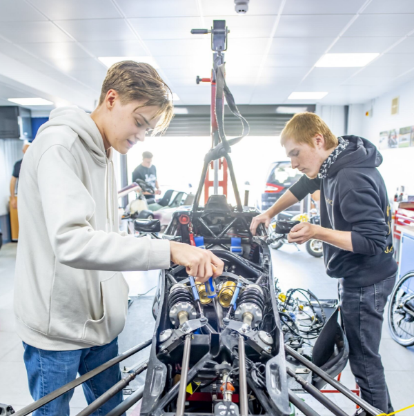 Two students working on an engine in a workshop