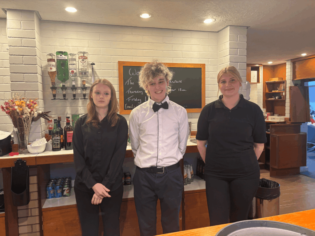 Three of our server students from the day stood behind the bar at the Arundel